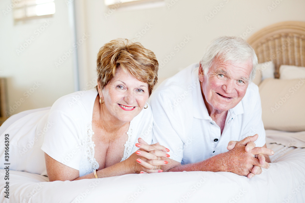 happy senior couple lying on bed happy senior couple lying on bed