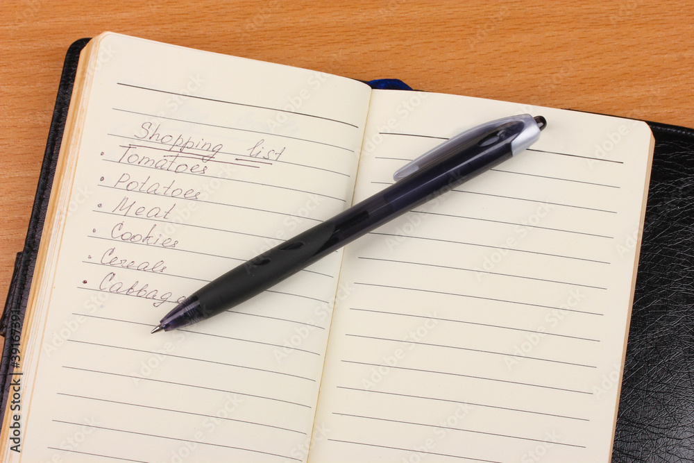 Shoping list and pen on wooden table Shoping list and pen on wooden table
