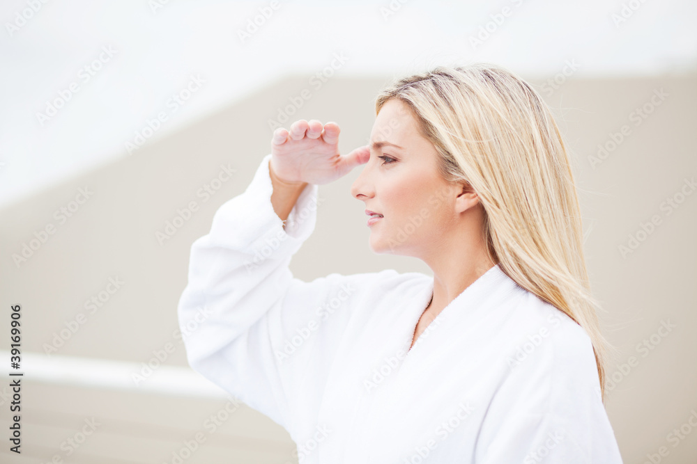 attractive young woman in bathrobe and looking into the distance attractive young woman in bathrobe and looking into the distance