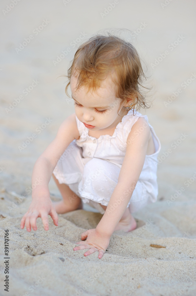 Adorable toddler girl playing on the beach Adorable toddler girl playing on the beach