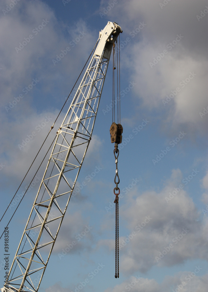 A Tall Jib Crane with Strong Metal Lifting Chains.