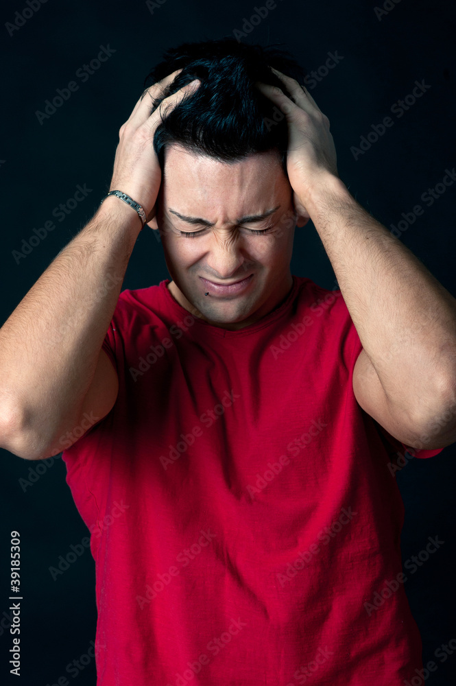 Man portrait with desperate expression on dark background. Man portrait with desperate expression on dark background.