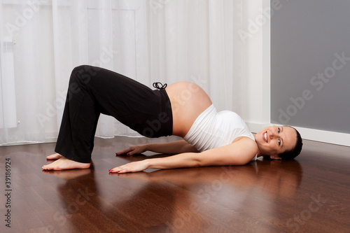 smiley pregnant woman doing exercise at home