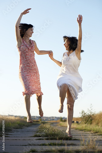 Two jumping Women, happy, smiling