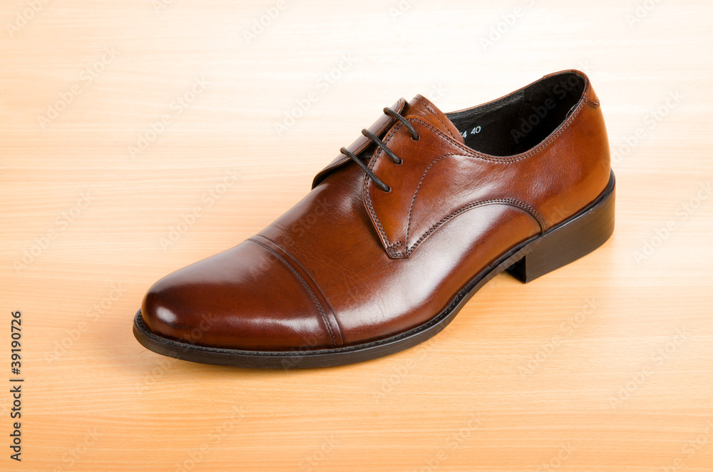 Brown shoes on wooden table Brown shoes on wooden table