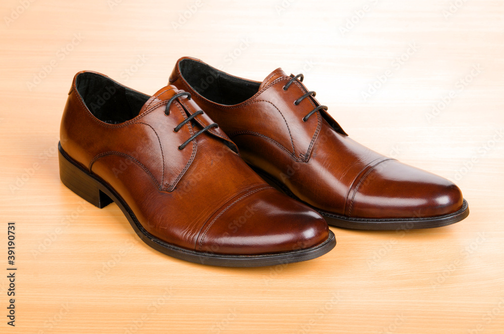 Brown shoes on wooden table Brown shoes on wooden table