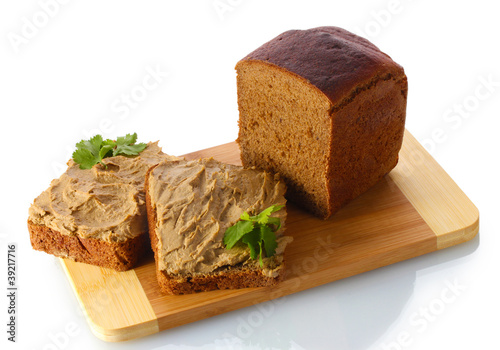 Fresh pate on bread on wooden board isolated on white