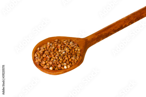 Wooden spoon with raw buckwheat isolated on white
