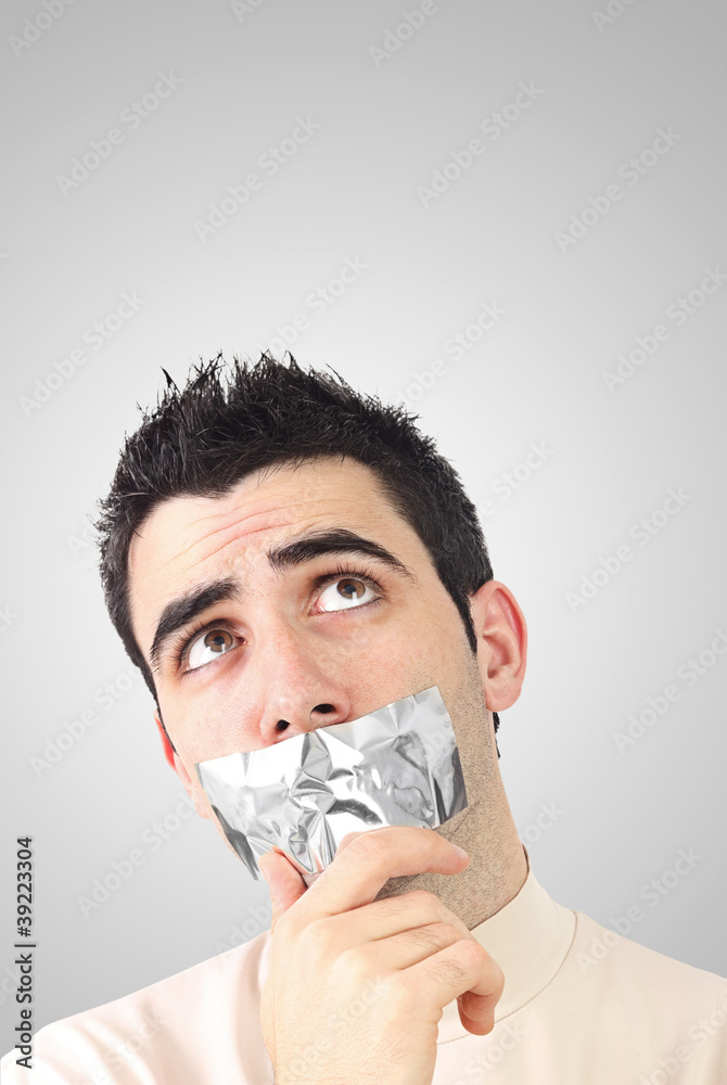 Curious young man having gray duct tape on his mouth