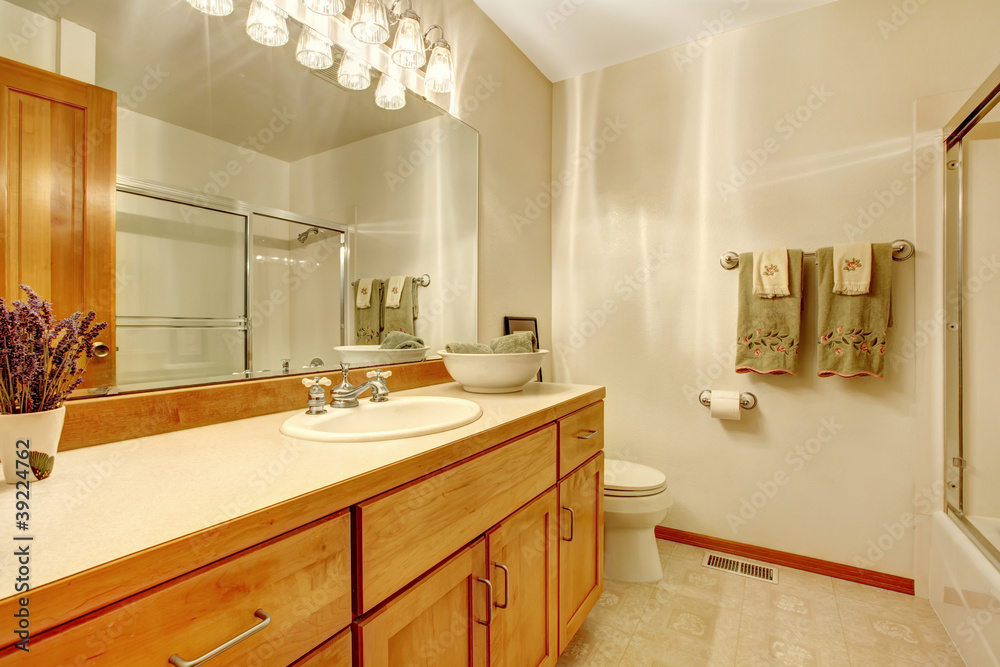 Fototapeta premium Outdated simple bathroom with wood cabinets,