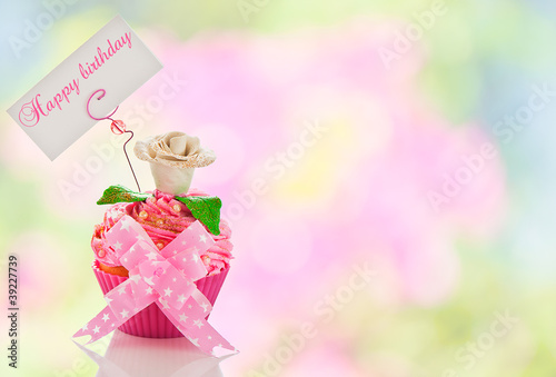 Photography A beautiful pink happy birthday cupcake with flower and a label