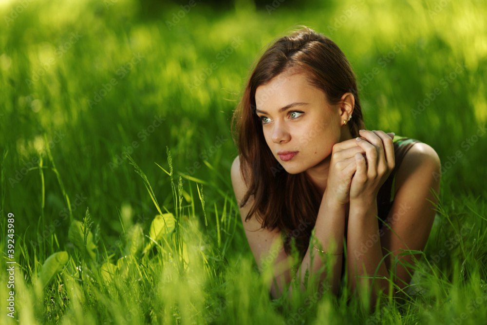 brunette lying on green grass brunette lying on green grass