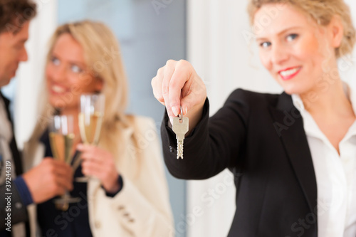 Paar bei Besichtigung einer Wohnung mit Maklerin photo
