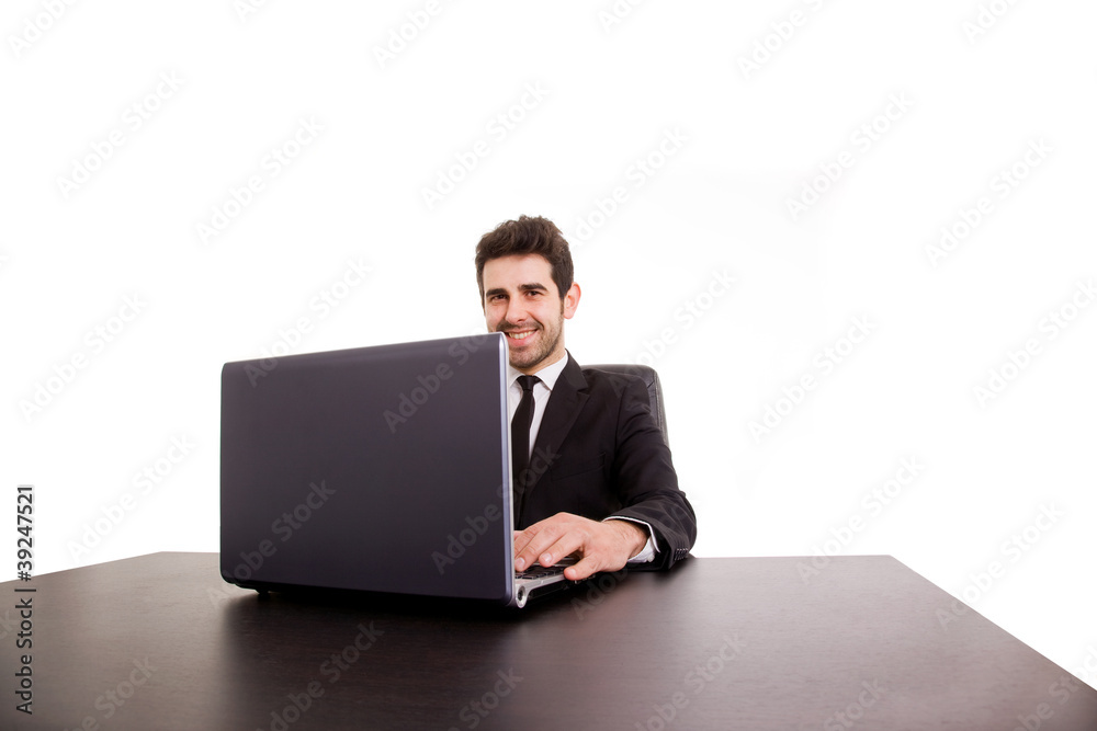 Smiling young business man working at office desk isolated on wh Smiling young business man working at office desk isolated on wh