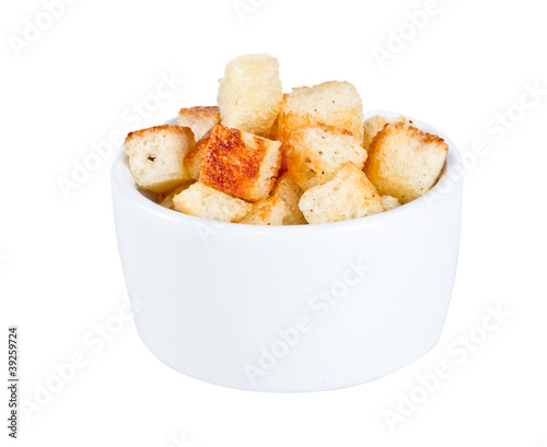 Crouton stack in a porcelain bowl and scattered isolated over wh