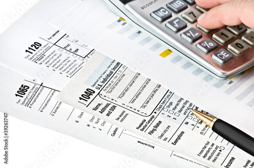 Tax forms with pen, calculator.