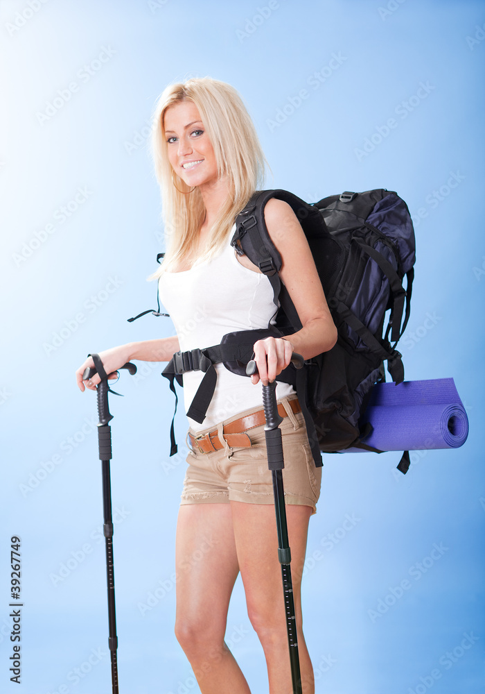 Young woman with backpack and jogging sticks