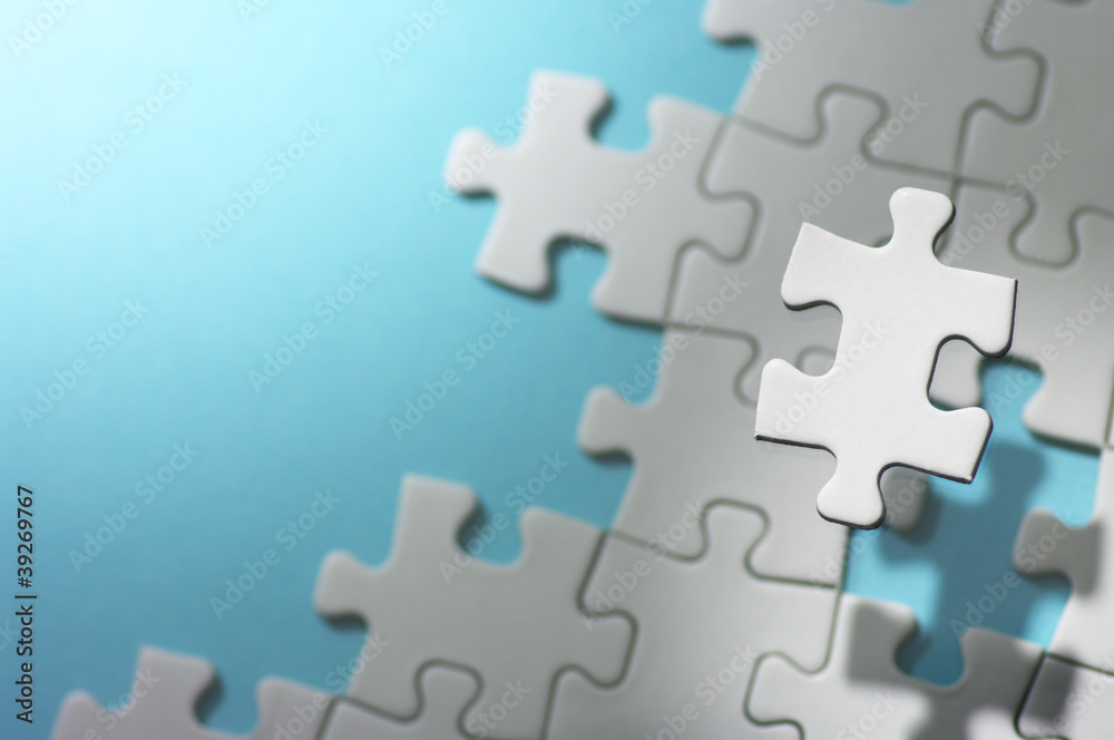 Floating jigsaw puzzle piece in spot light.