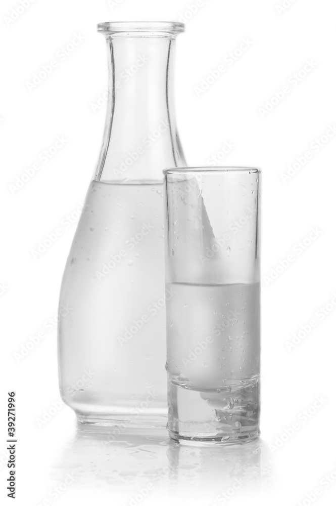 Decanter and glass of iced vodka with drops on white background Decanter and glass of iced vodka with drops on white background