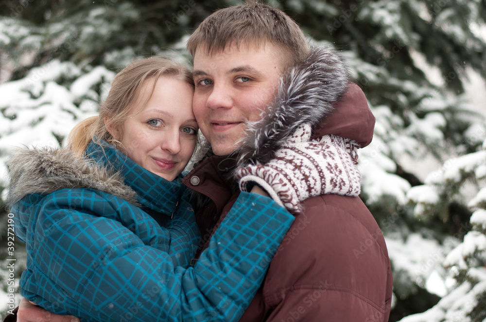 Fototapeta premium Young lovers woman and man in a winter forest
