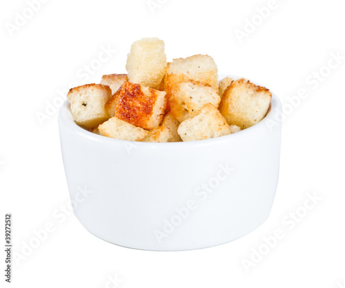 Crouton stack in a porcelain bowl and scattered isolated over wh