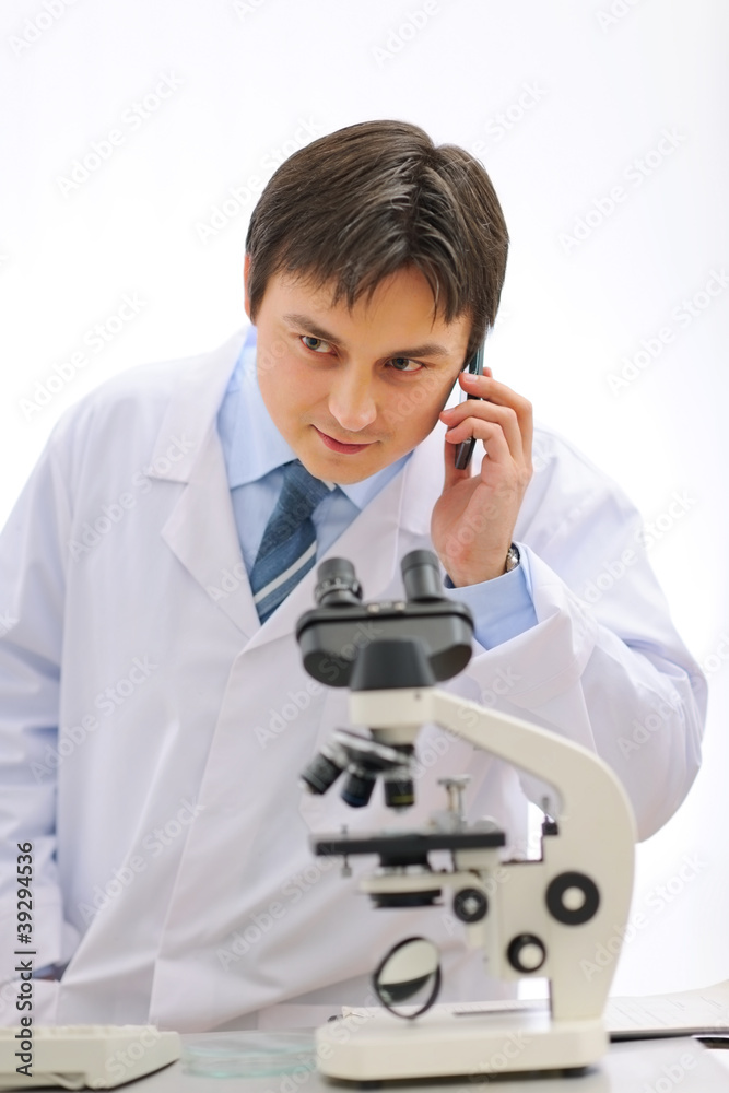 Male researcher speaking cellular in laboratory Male researcher speaking cellular in laboratory