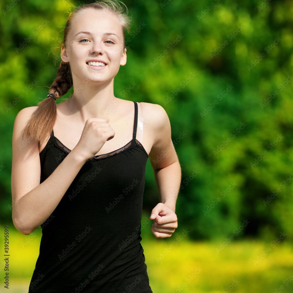 Young woman running in green park Young woman running in green park