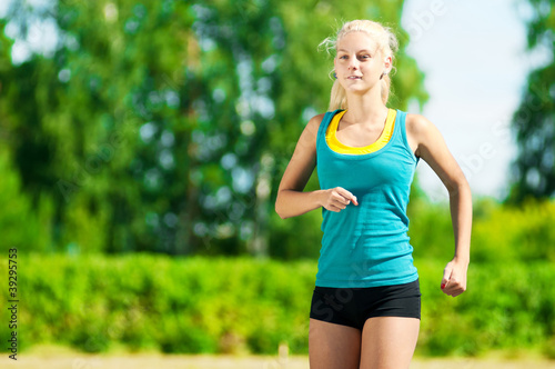 Young woman running in green park