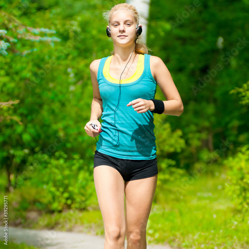 Beautiful young woman running on music