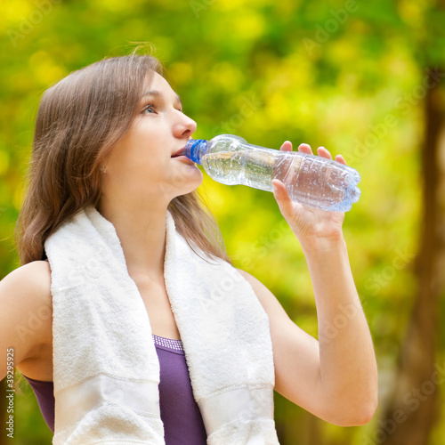 Woman drinking water after fitness exercise