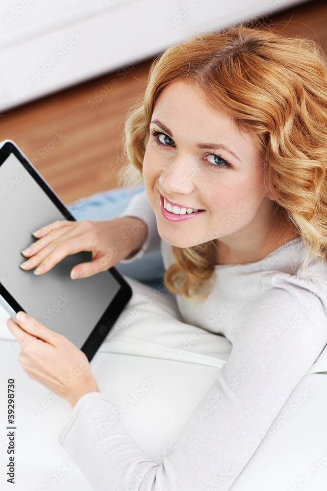 Blond woman relaxing in sofa using electronic tablet Blond woman relaxing in sofa using electronic tablet