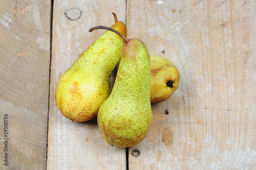 Three pears on wooden background photo