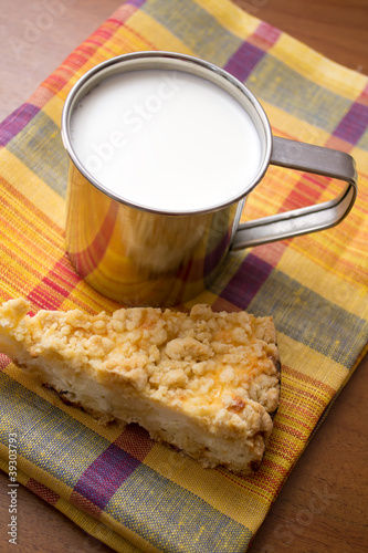 cup of milk and a piece of cake on the table photo