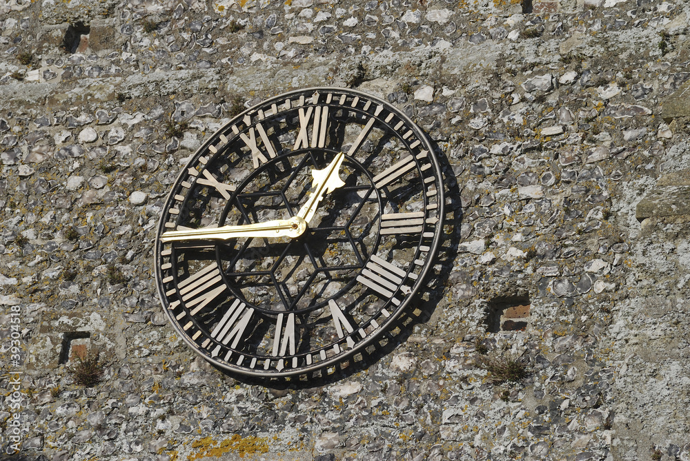 Church clock on flintstone wall