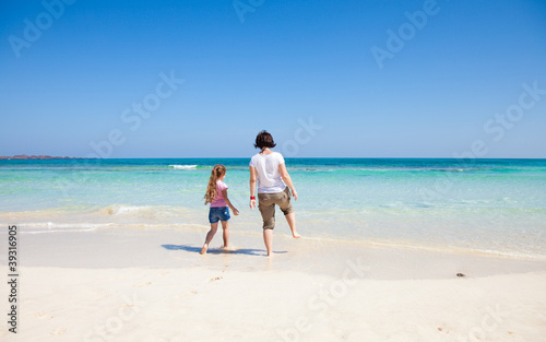 mother and daughter play at the edge of the ocean