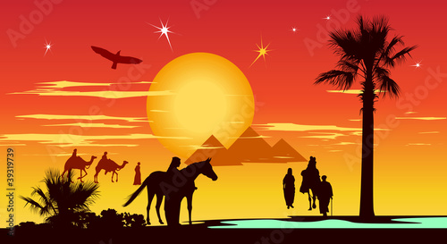 Travelers around the pyramids and palm-trees