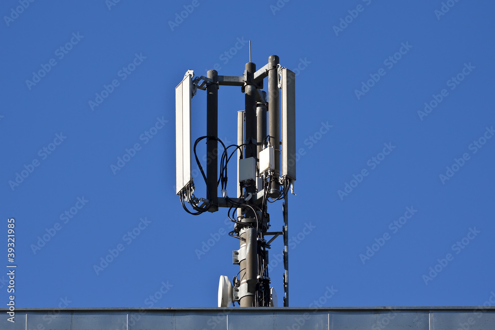 Mobilfunkantenne auf Dach, blauer Himmel