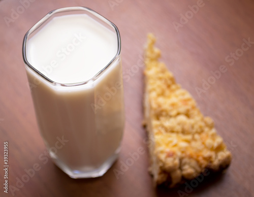 glass of milk and a piece of cake on a wooden table
