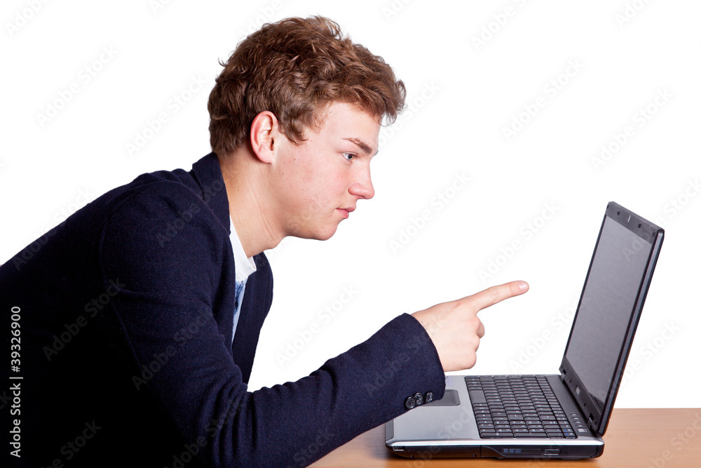 Junger Mann zeigt mit Finger auf Laptop Junger Mann zeigt mit Finger auf Laptop