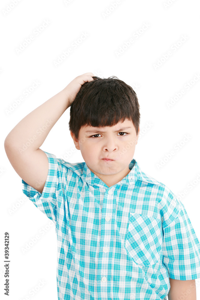 Boy scratches his head in puzzlement or confusion, as if ponderi Boy scratches his head in puzzlement or confusion, as if ponderi