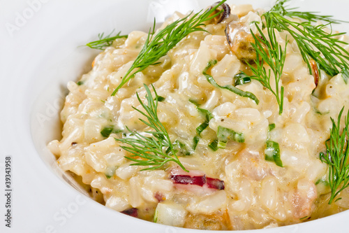 photo of delicious risotto with seafood and dill on it