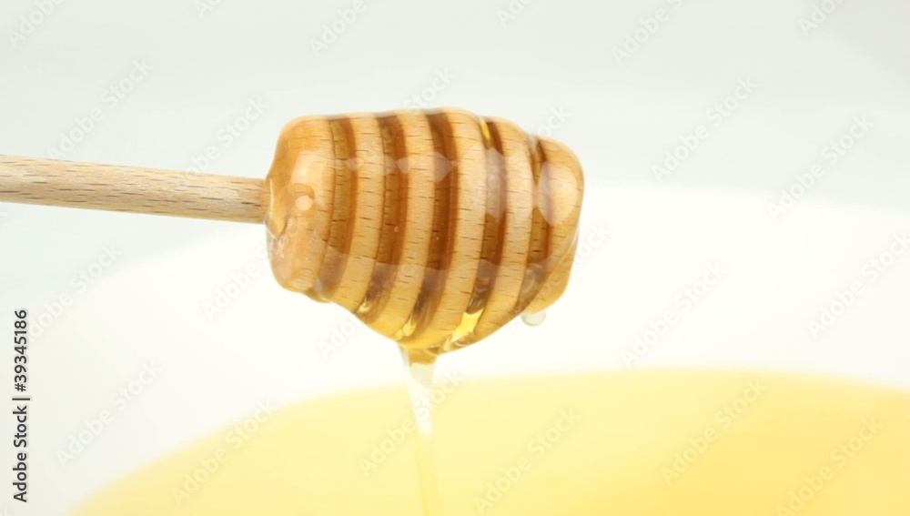 Honey dripping from wooden dipper Honey dripping from wooden dipper