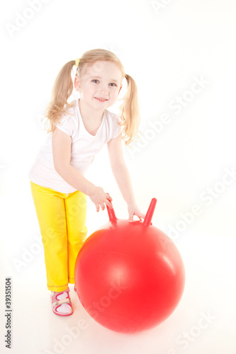 cute sly little girl doing gymnastic exercise with ball