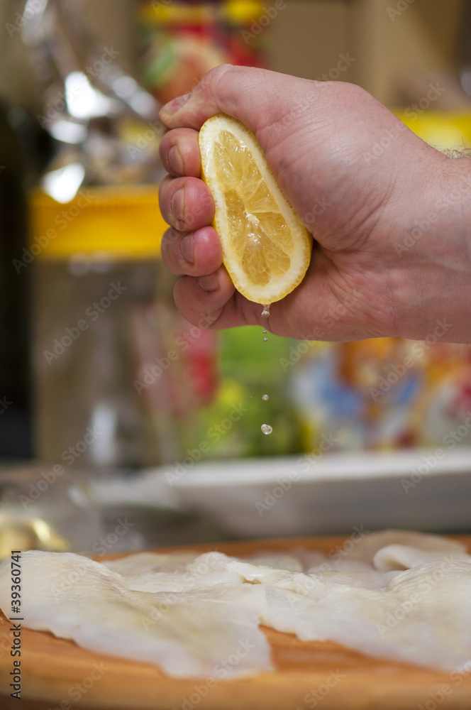 squeezing lemon juice on fish fillets Stock Photo | Adobe Stock