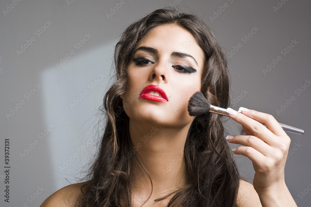 Obraz premium Beautiful girl applying makeup