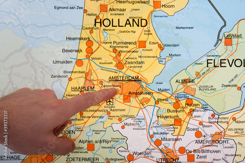 A Dutch map with a hand pointing to the capital city Amsterdam