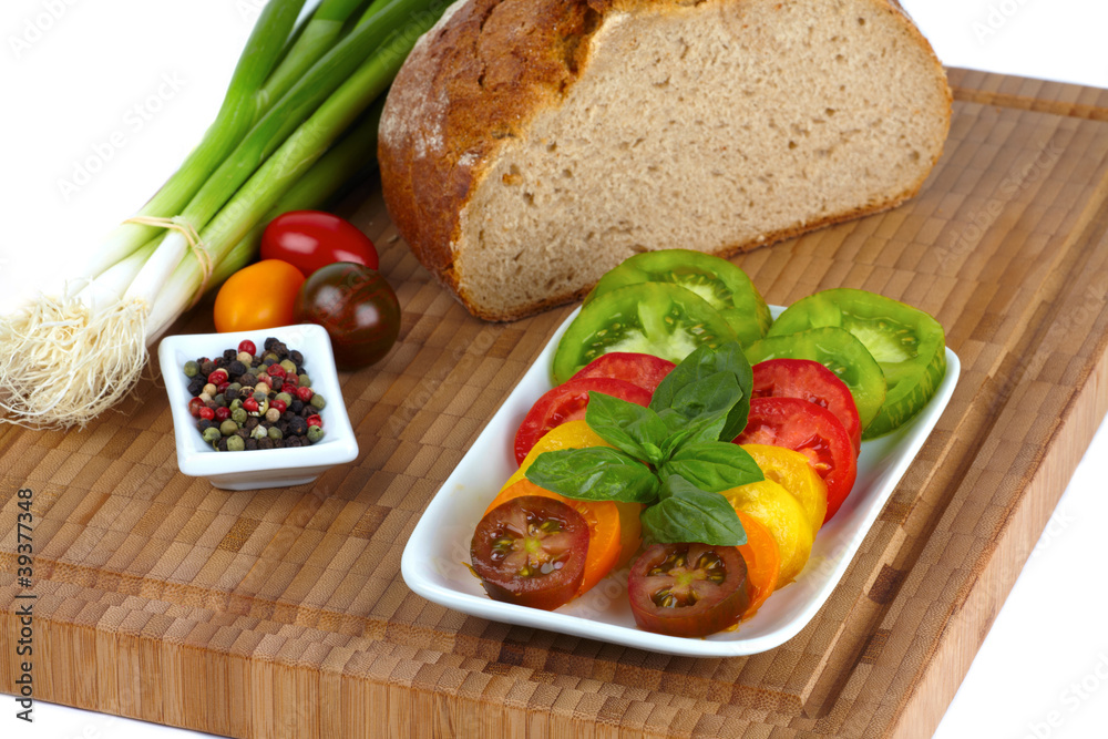 Geschnittene Bio Tomaten mit Brot auf Schneidebrett Geschnittene Bio Tomaten mit Brot auf Schneidebrett