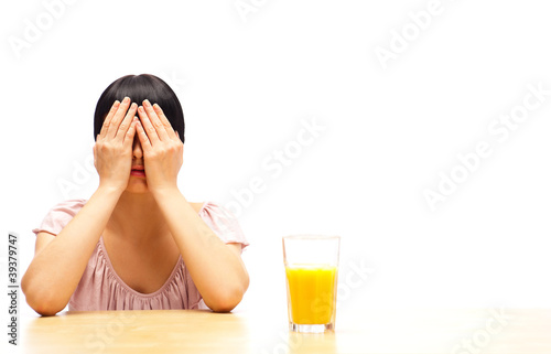 Woman sitting at kitchen with glass of orange juice photo