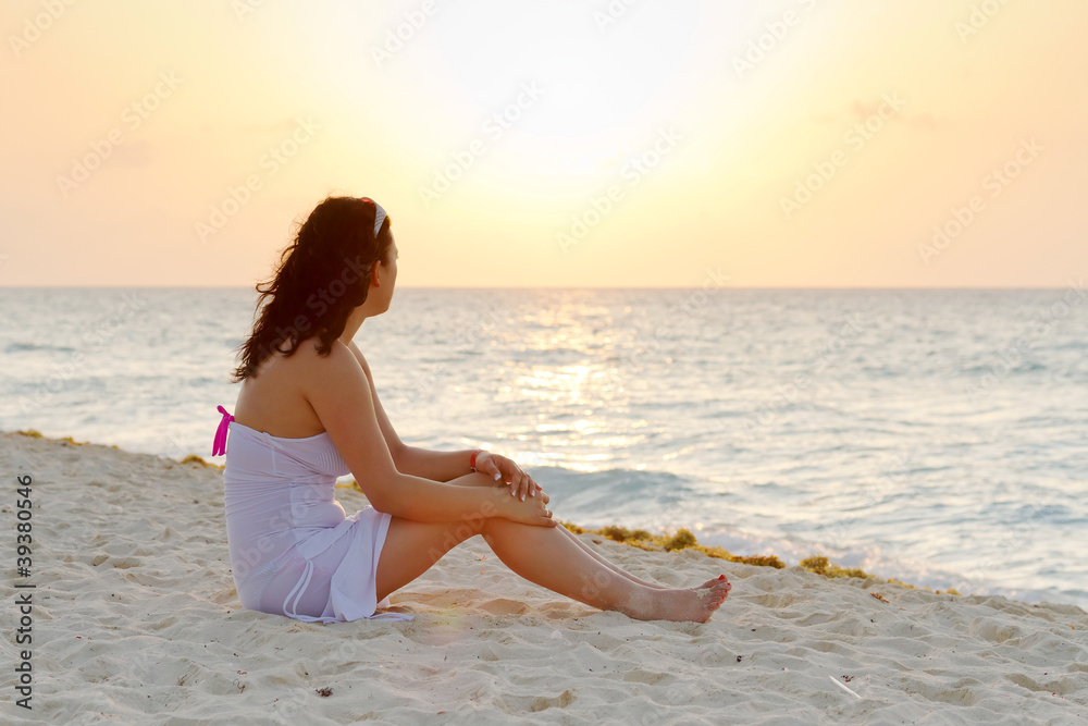 Beautiful woman watching sunrise on the beach Beautiful woman watching sunrise on the beach