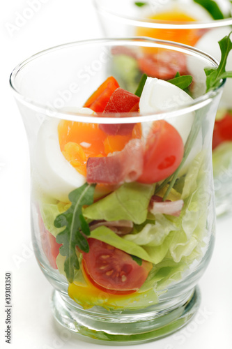 Weich gekochtes Ei im Glas mit Schinken und Salat